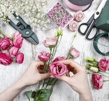 Florist at work. Woman making beautiful bouquet of pink eustoma flowers